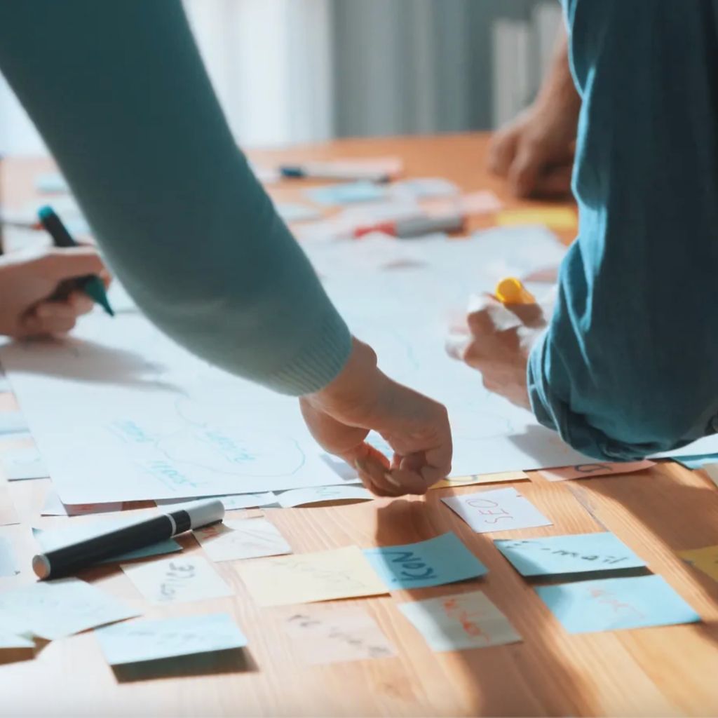 Collaborative brand clarity session with notes and sketches spread across a table